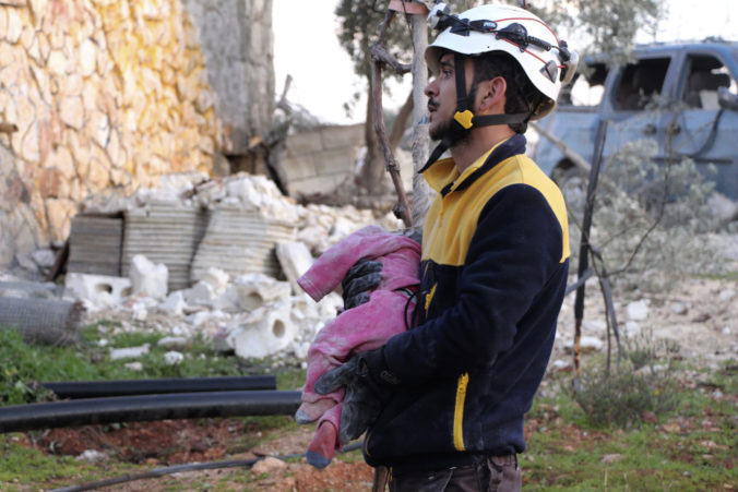 Pracovník civilnej obrany v Sýrii nesie detskú obeť. Foto: SITA/AP, Syrian Civil Defense White Helmets